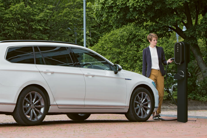 A photo of a woman connecting her VW Passat vehicle to a car park EV charger